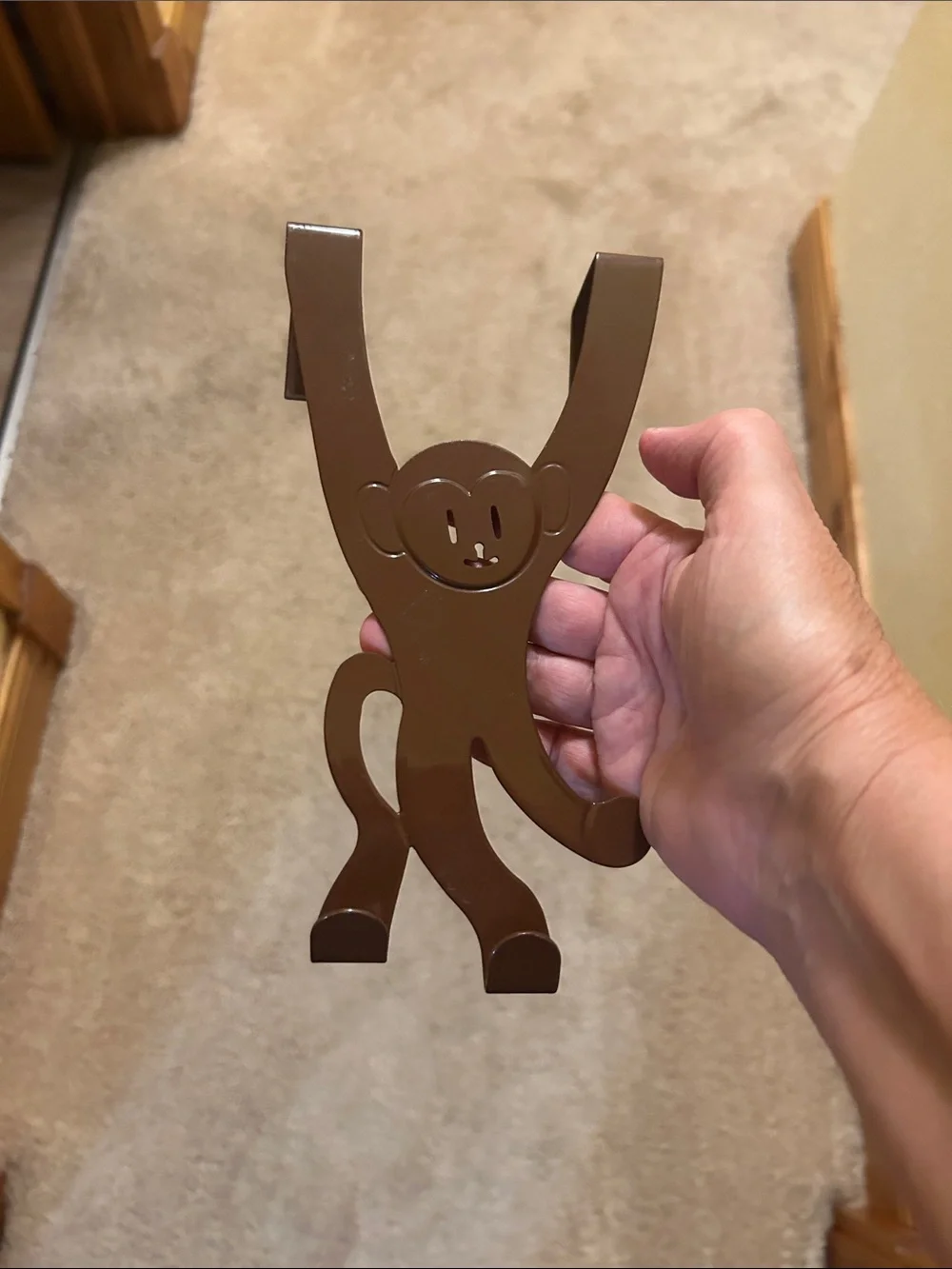 A set of 3 whimsical brown metal monkey over-the-door hooks